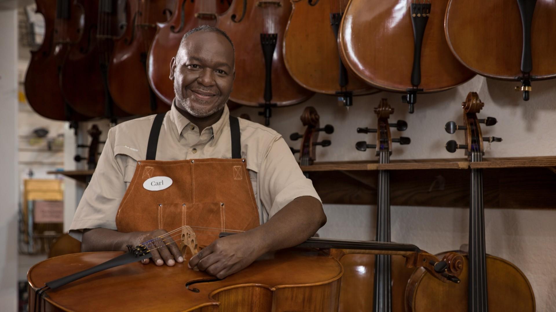 Owner of a small business with a cello on his lap.