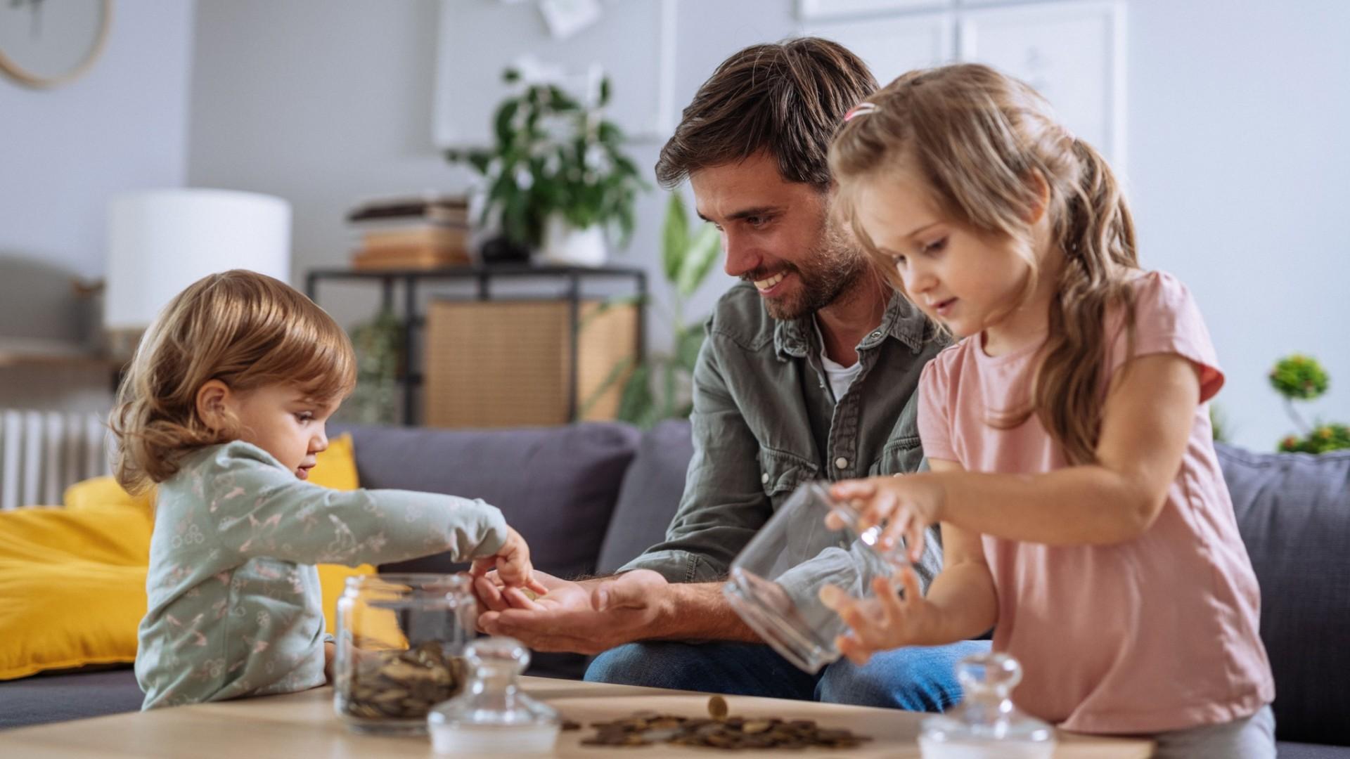 Father and daughters counting change at home.