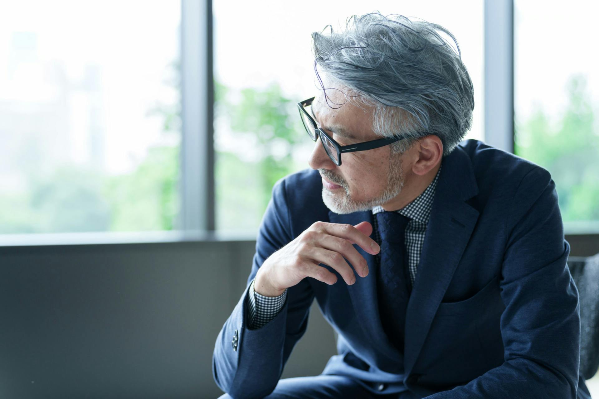 Portrait of a middle-aged Asian businessman wearing eyeglasses.