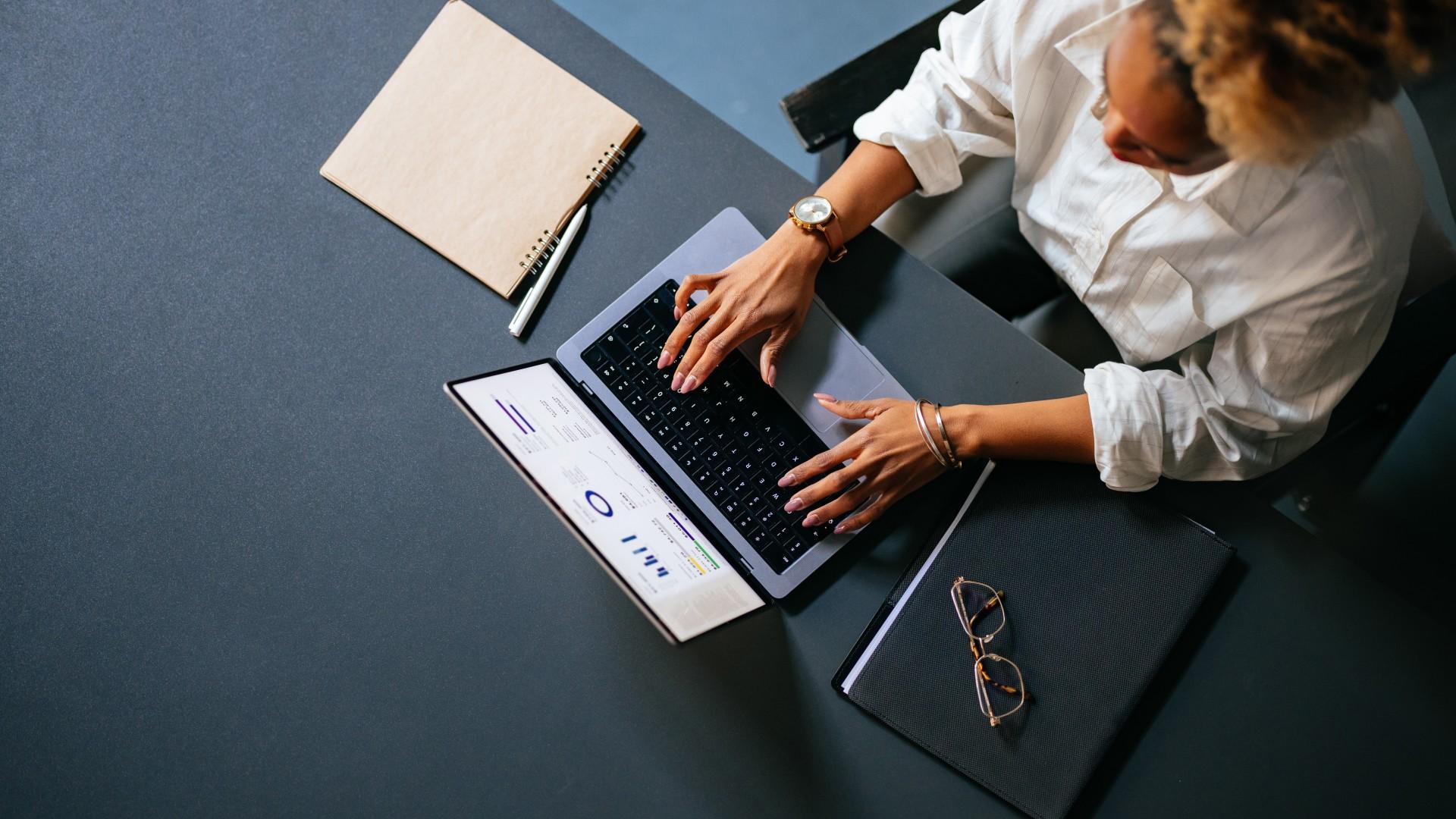 A woman is sitting at a home office desk doing finances.