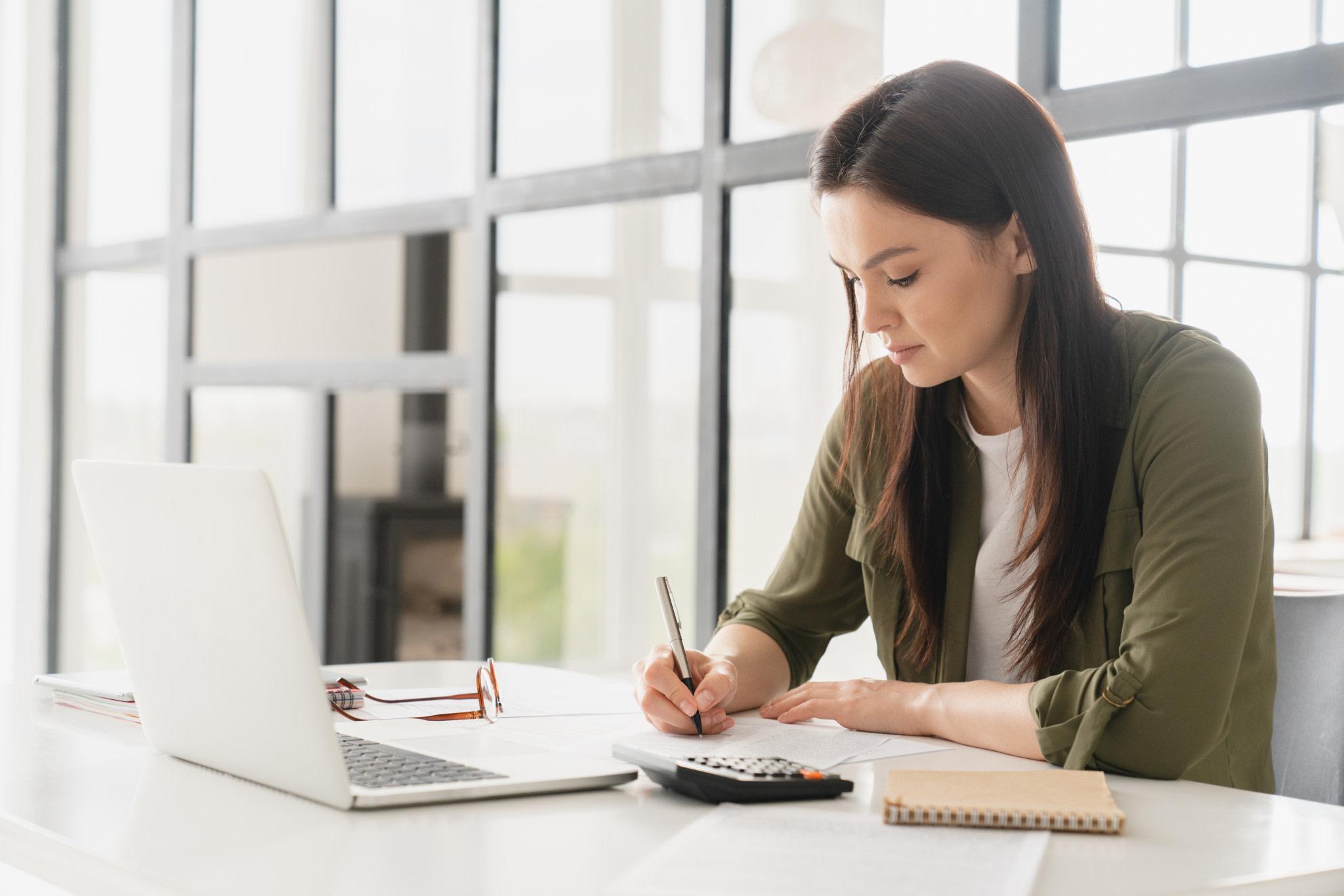 A business woman at a desk doing finances.