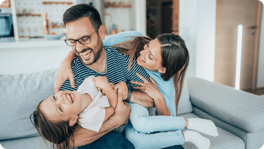 A family laughing together on a couch